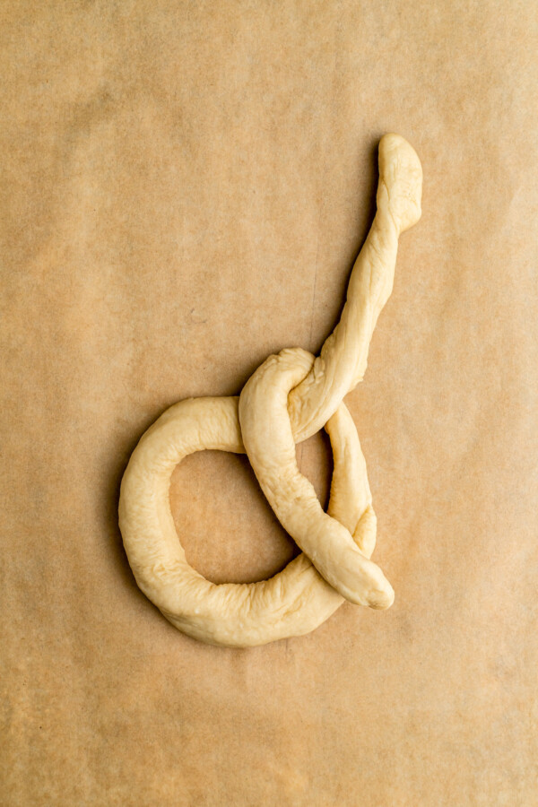 One of the top x parts of the dough crossed over the loop at the bottom to being to form the pretzel shape.