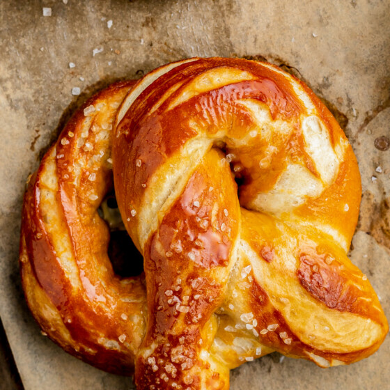A soft and chewy homemade pretzel with butter brushed on top and pretzel salt.