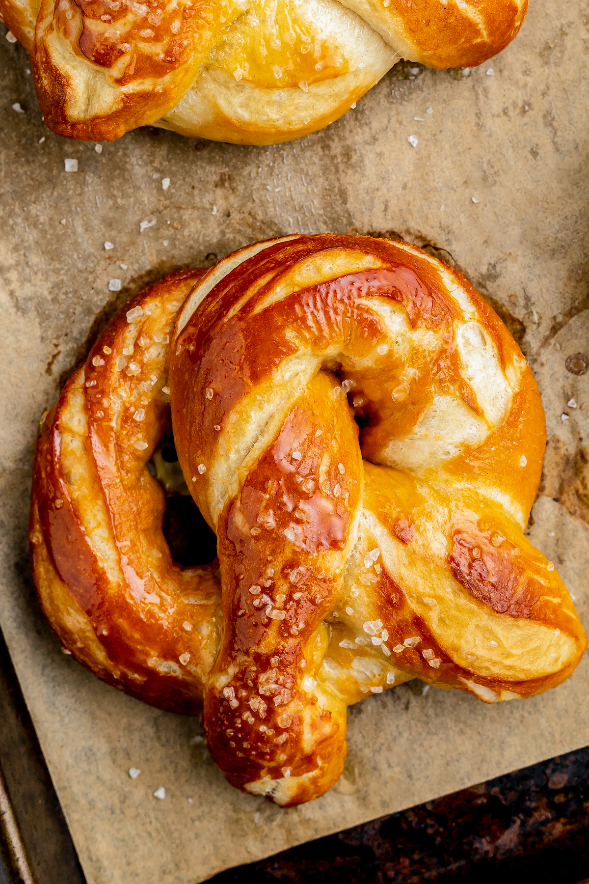 A soft and chewy homemade pretzel with butter brushed on top and pretzel salt.