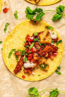 Authentic Tacos al Pastor with smoky, juicy pork, sweet grilled pineapple, salsa, diced onion and fresh cilantro.