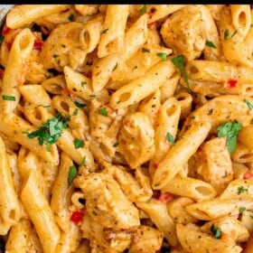 A skillet filled with creamy cajun chicken pasta with tender chicken and penne pasta in a spicy and creamy sauce.