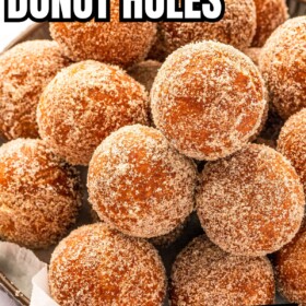 Homemade donut holes coated in cinnamon sugar and served on a tray.