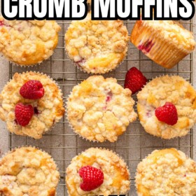 Raspberry crumb muffins with white chocolate chips on a cooling rack.