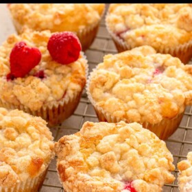 Raspberry muffins with crumb topping on a wire cooling rack.