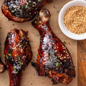 Tender Asian baked drumsticks with a sweet and sticky marinade topped with fresh herbs and sesame seeds.