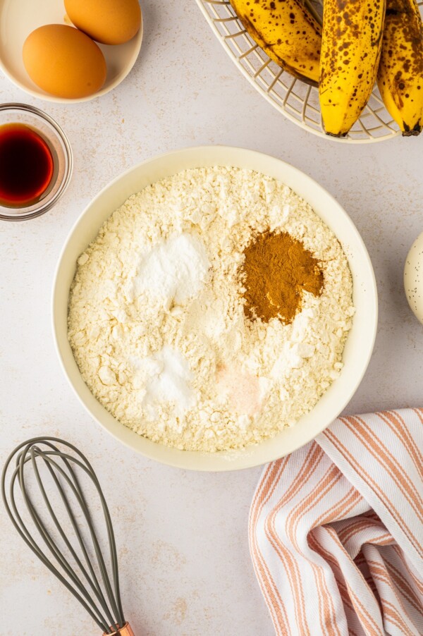 Dry ingredients being added and whisked together in a bowl.