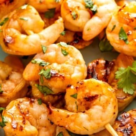 Sweet and sticky grilled shrimp skewers made with honey and lemon zest and topped with fresh cilantro.