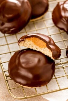 A tagalong cookie cut in half to show the layers of rich chocolate, creamy peanut butter filling and buttery shortbread cookie.