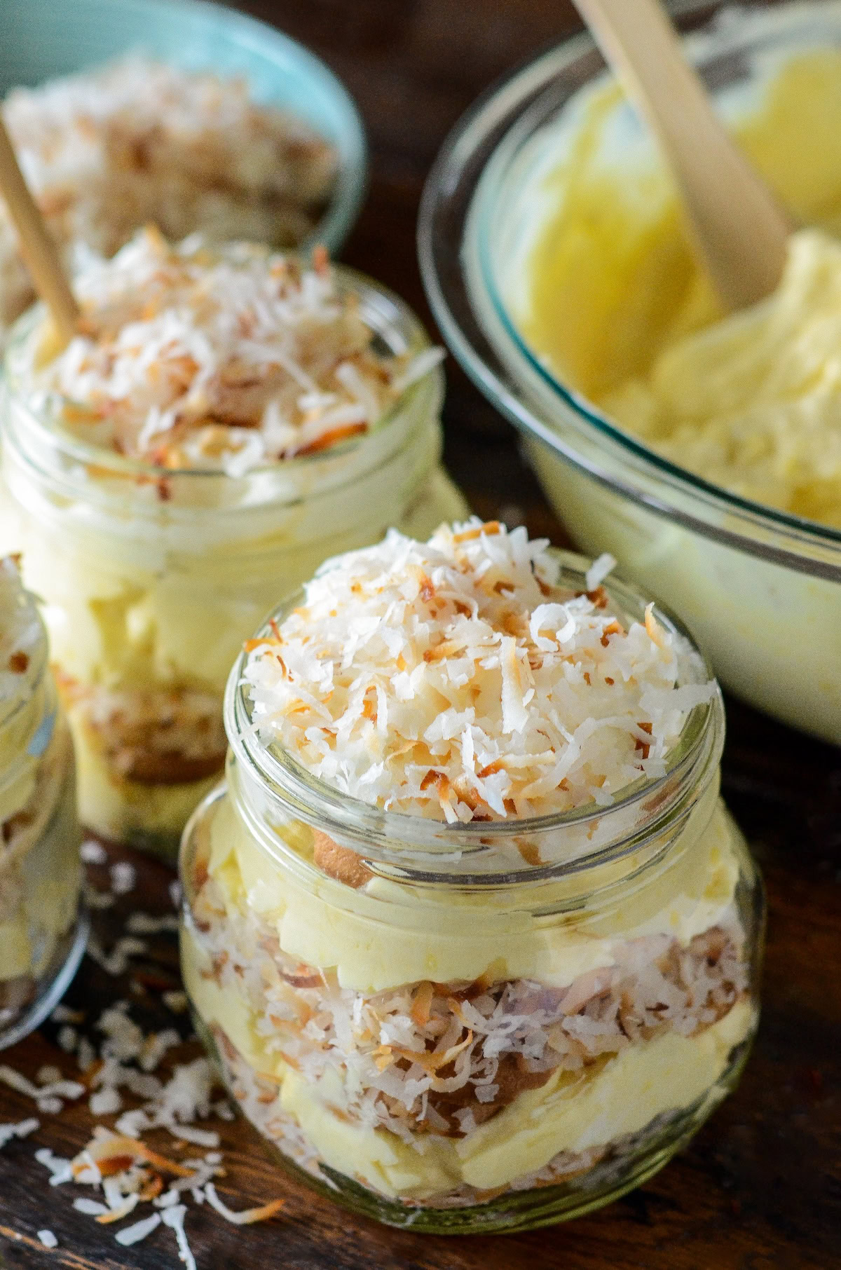 A jar of coconut cream pudding with toasted shredded coconut on top.