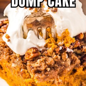 A serving of pumpkin dump cake with toffee and pecan topping served on a plate with whipped cream on top and a fork taking a bite.