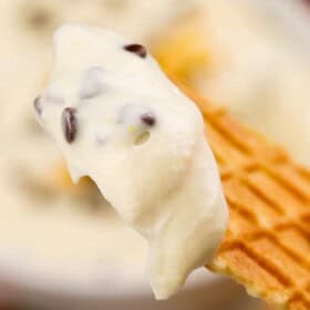 A cookie dipped into chocolate orange cannoli dip.