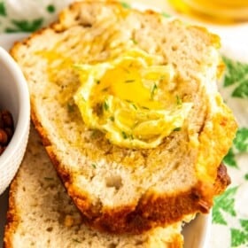 Two slices of easy beer bread topped with butter and honey.