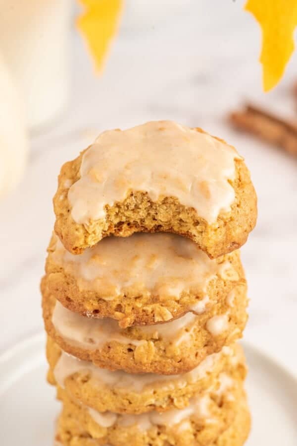 A bite has been taken out of a soft pumpkin oatmeal cookie.