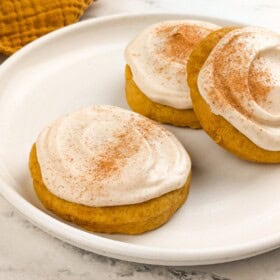 Pumpkin cookies with cream cheese icing dusted with cinnamon.