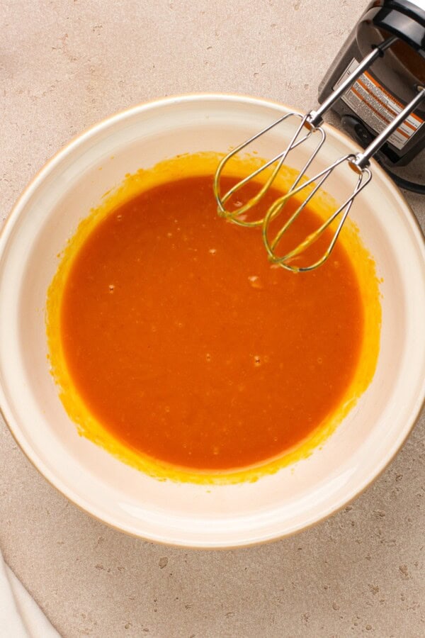 Ingredients being mixed in a large white bowl.