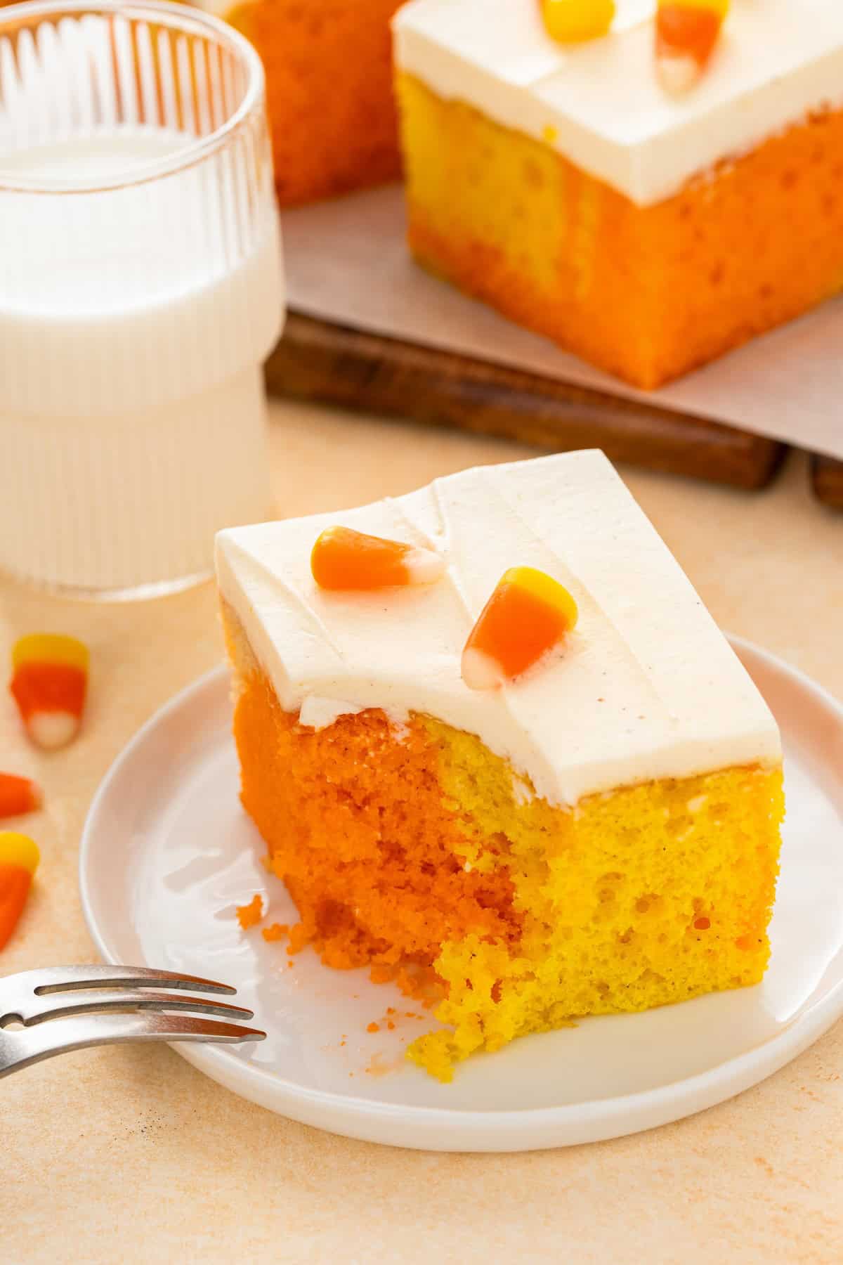 A bite has been taken out of a candy corn poke cake.