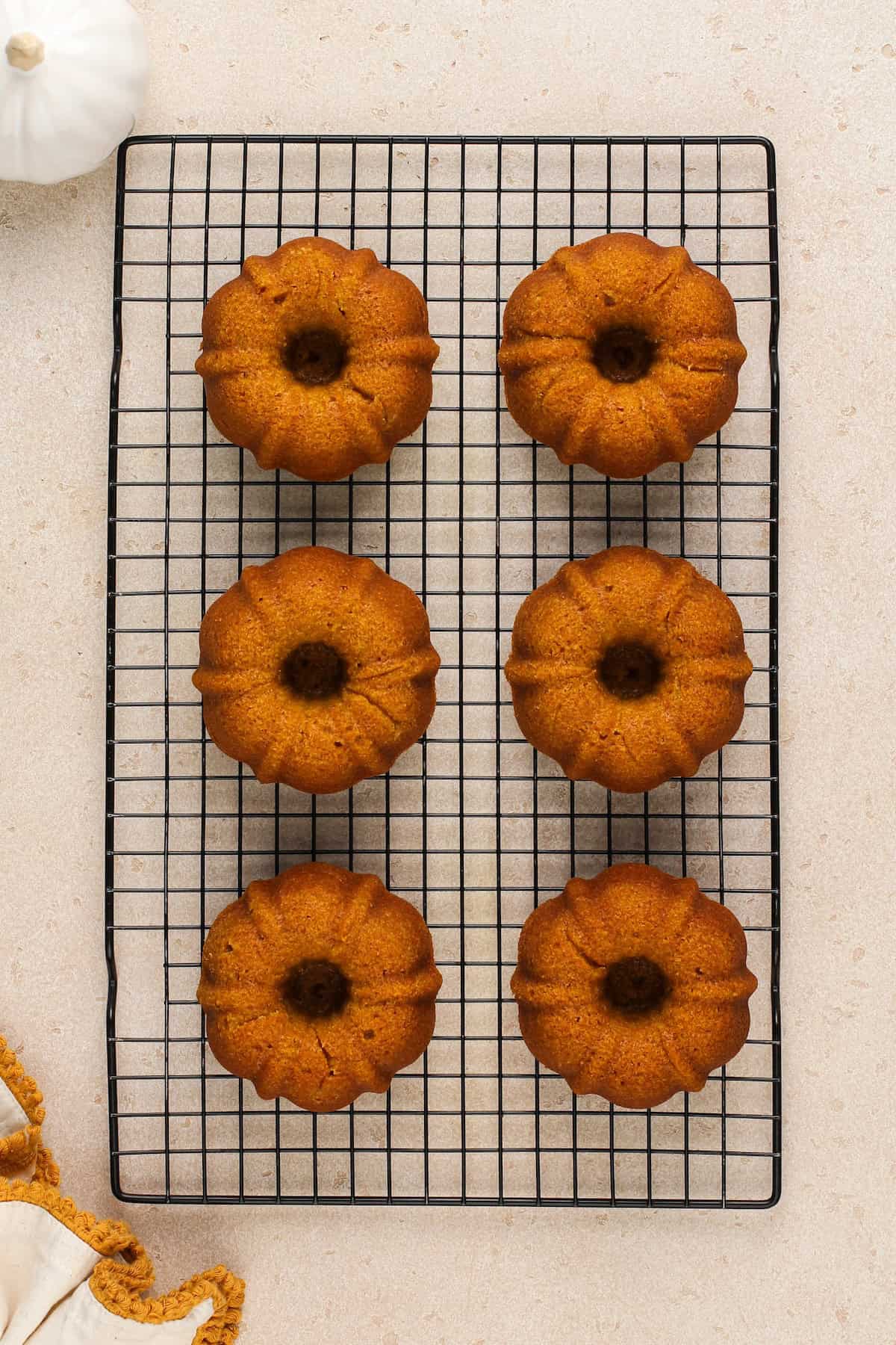 Pumpkin spice bundt cakes cooling on a wire rack.