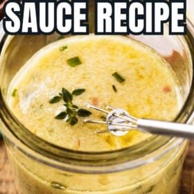 A jar filled with garlic herb steak sauce with a small whisk in the jar.