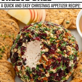 Christmas cheese ball recipe with cranberries and pecans served with crackers and apples.