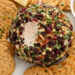 A single scoop has been removed from a cranberry cheese ball.