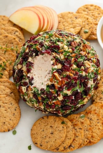 A single scoop has been removed from a cranberry cheese ball.