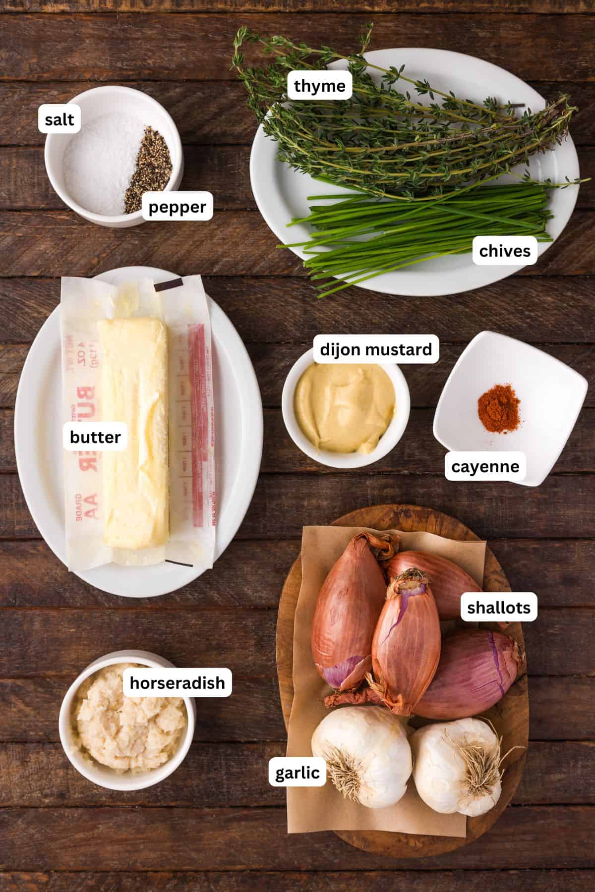 Ingredients for homemade steak sauce recipe arranged in bowls, from top to bottom: salt, pepper, thyme, chives, butter, Dijon Mustard, cayenne, shallots, horseradish and garlic.