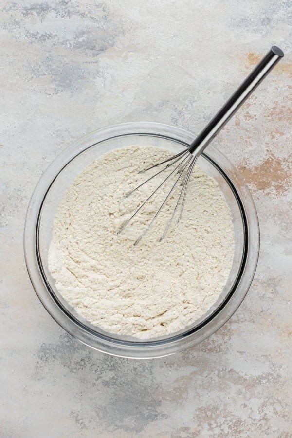 A bowl of dry cake ingredients being whisked together.