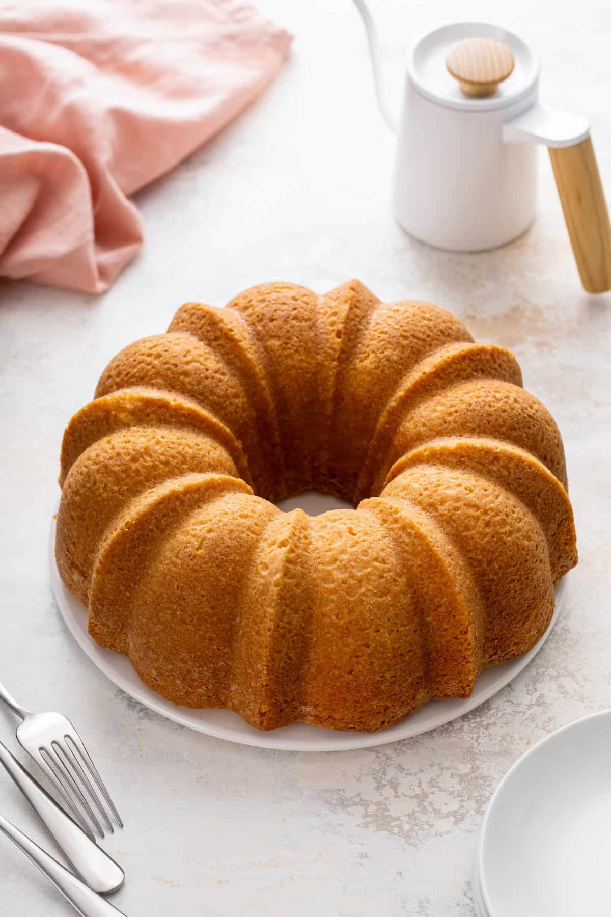 Baked bundt cake cooling on a cake plate.