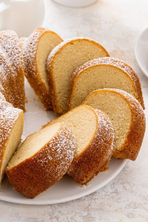 Buttermilk pound cake sliced into pieces dusted with powdered sugar on top.