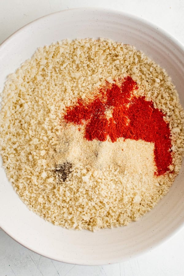 Seasonings are being mixed into breadcrumbs.