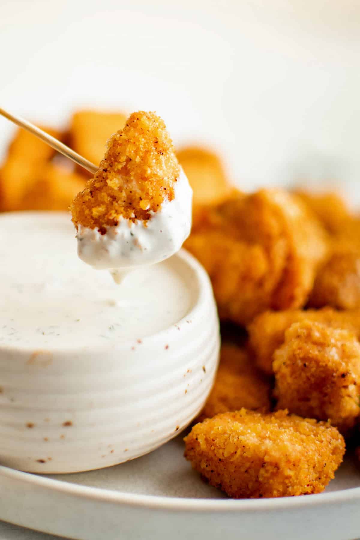 Crispy salmon nugget is dipped in creamy dill garlic sauce.