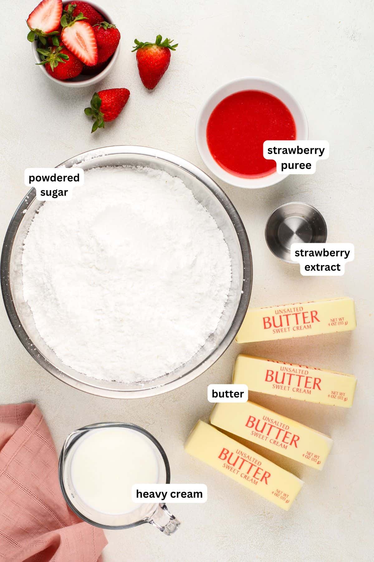 Ingredients for strawberry buttercream frosting recipe in order from top to bottom: strawberry puree, powdered sugar, strawberry extract, butter, heavy cream.