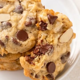 Chewy almond joy cookies are placed on a white plate.