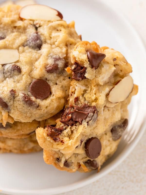 Chewy almond joy cookies are placed on a white plate.