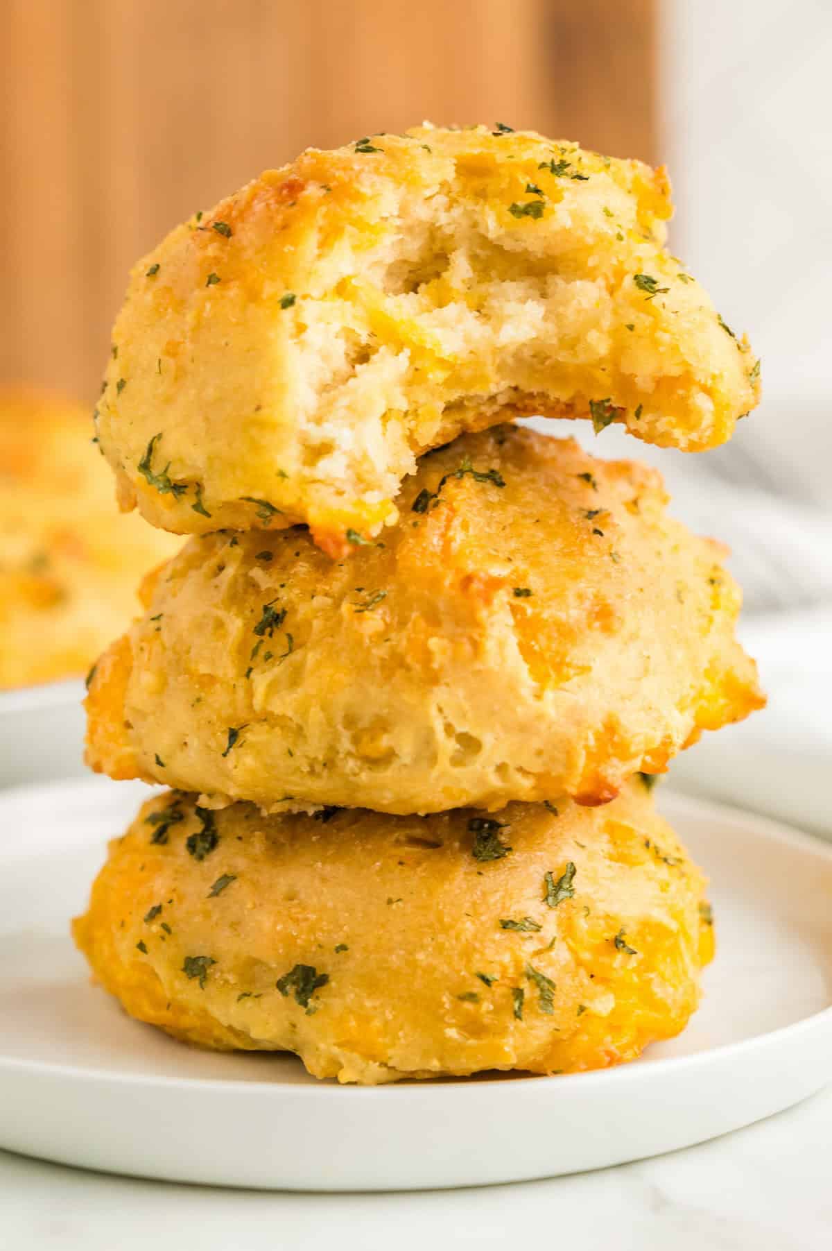 A bite has been taken out of a cheddar biscuit to reveal a fully cooked center.