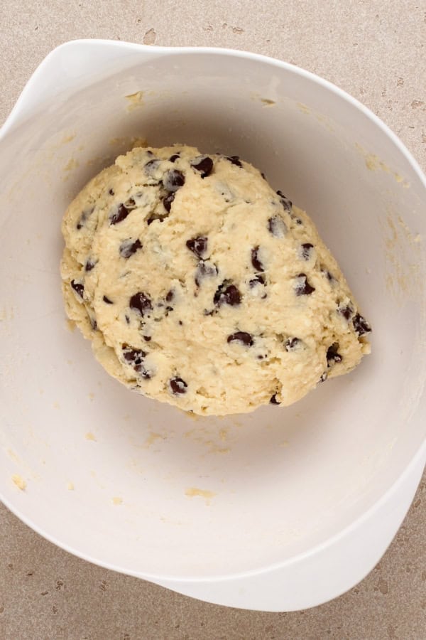 Scone dough has been combined and formed into a ball in a large white mixing bowl.