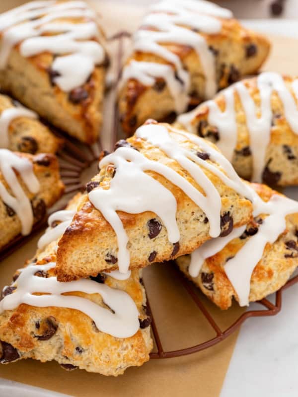 Chocolate chip scones with sweet icing on top are presented in a small circle.