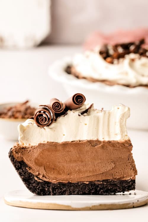 A thick slice of French silk pie is presented on a round plate.