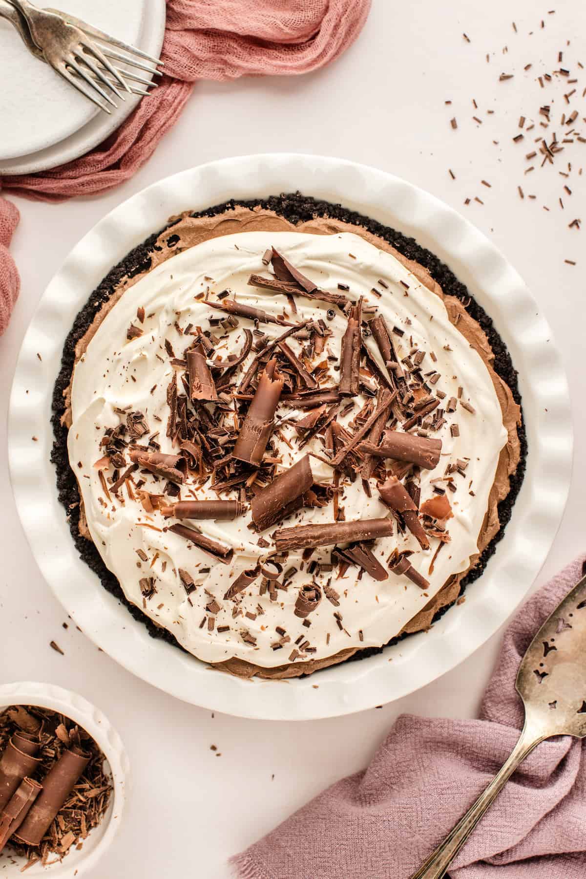 Chocolate shavings and curls are sprinkled on top of a fully assembled French silk pie.