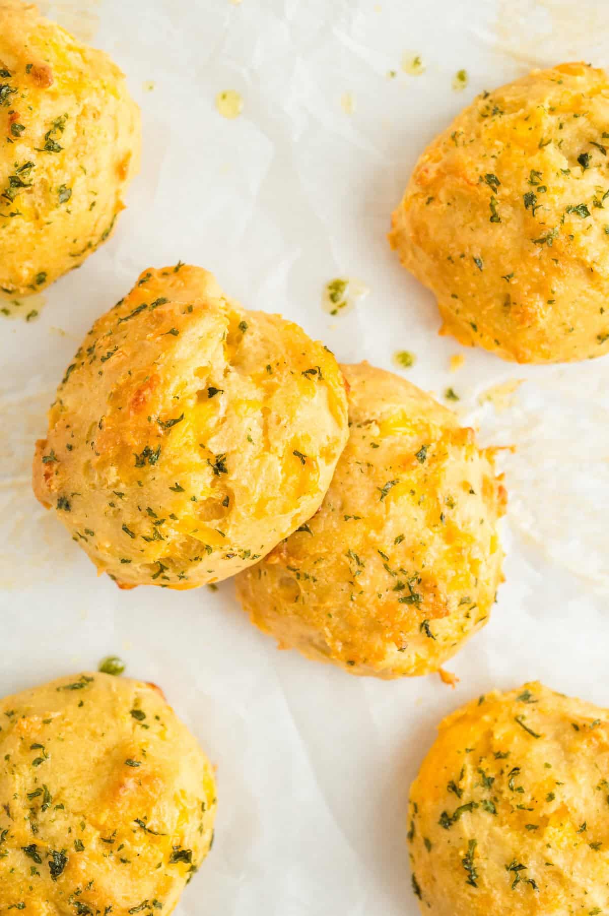 Buttery, soft biscuits are spread on a sheet of parchment paper.