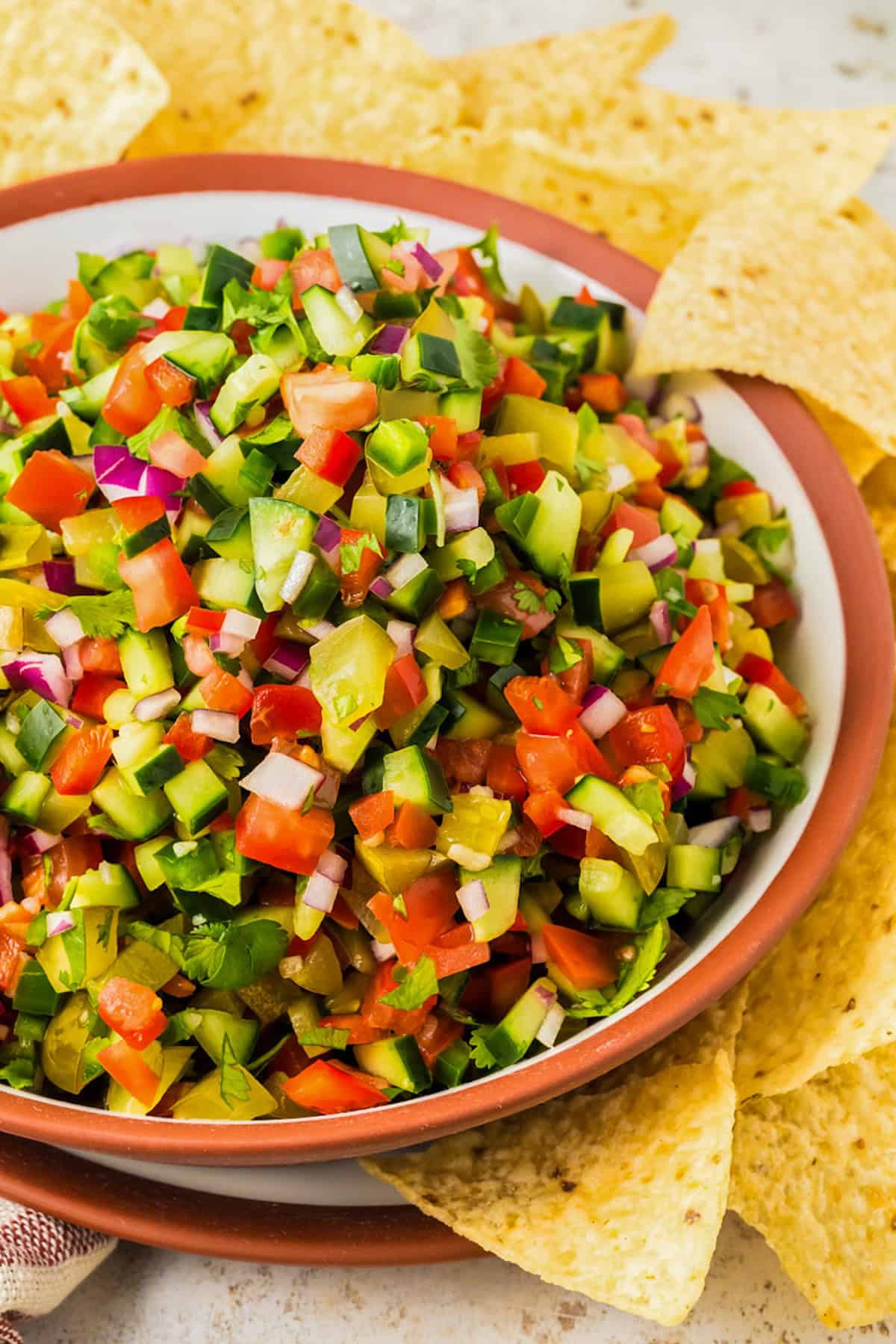 Calling all pickle lovers! This tangy Pickle de Gallo recipe is a game-changing condiment that adds a fresh, tangy twist to any meal. Fresh pickle de gallo presented in a bowl with crunchy tortilla chips on the side.