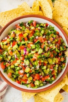 A large serving bowl is filled with fresh pickle salsa.