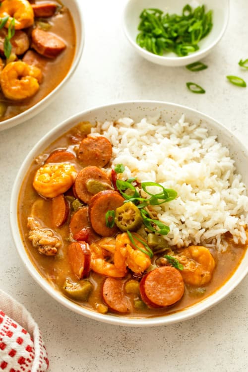 White rice and seafood gumbo served in a single white bowl.