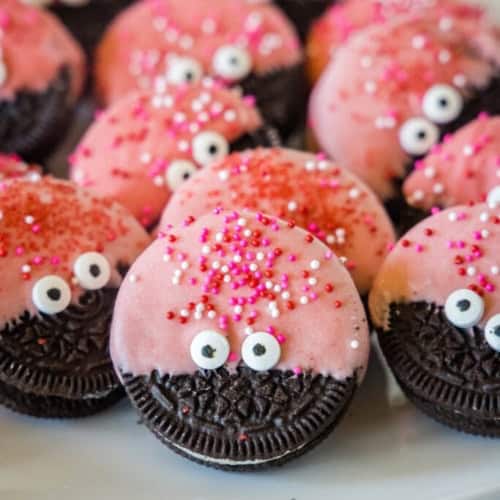 Love bug Oreo cookies decorated for valentines day on a plate.