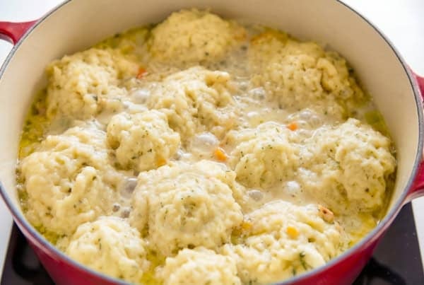 The best homemade Chicken and Dumplings recipe you'll ever make! Ready in under an hour with a thick creamy broth, juicy chicken, and big fluffy dumplings. A pot of homemade chicken and dumplings, with fluffy, golden dumplings simmering on top of a creamy, bubbling broth filled with bits of shredded chicken and vegetables.