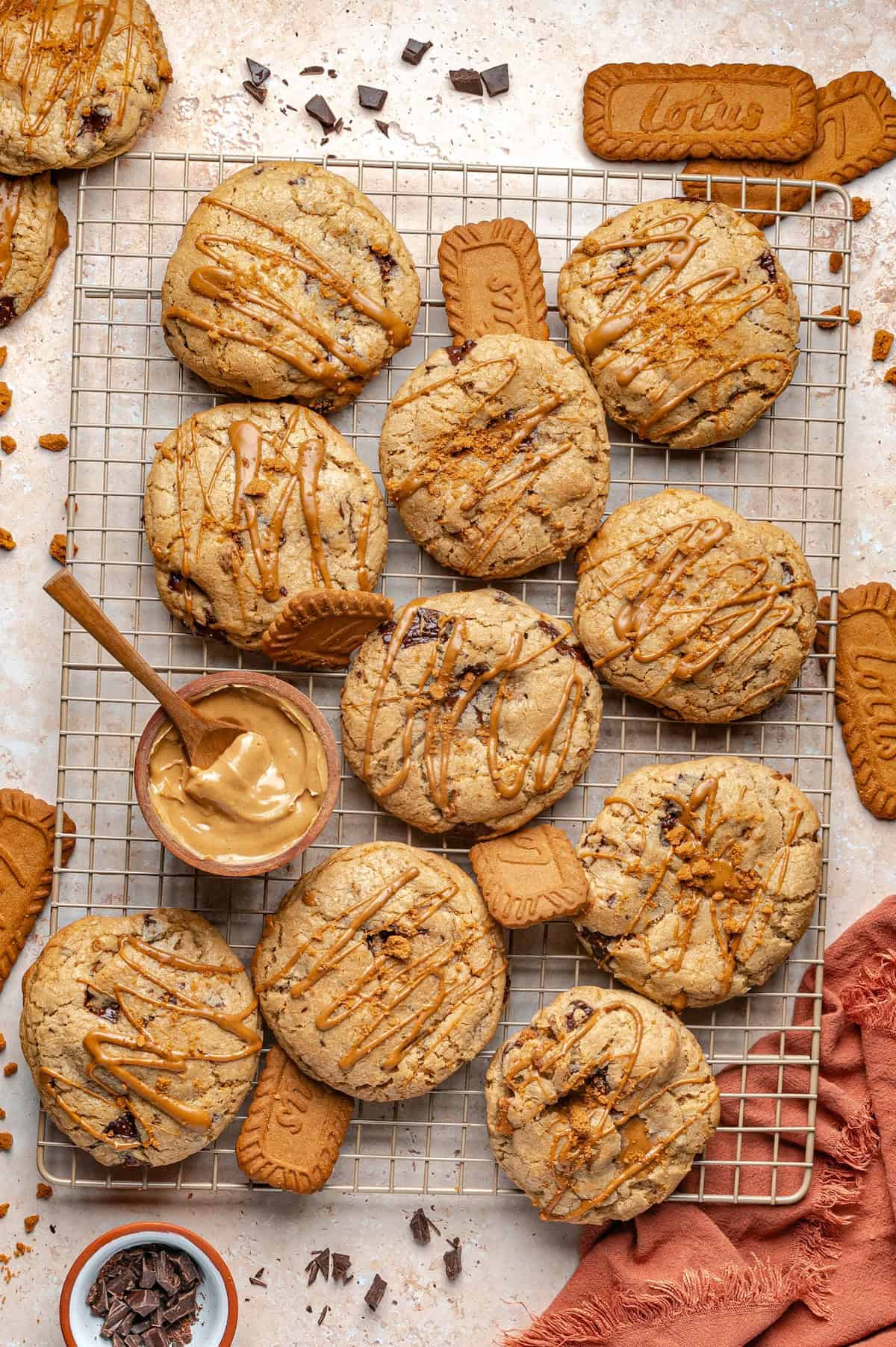 Stuffed Biscoff Cookies with a molten cookie butter center, crushed Biscoff cookies, and dark chocolate are for serious Biscoff lovers! Large stuffed cookie butter cookies topped with a drizzle of cookie butter and crushed biscoff cookies butter arranged on a cooling rack.
