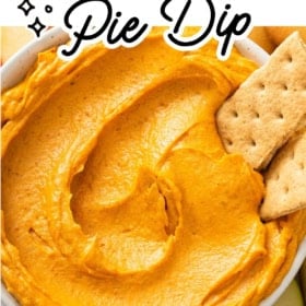 A bowl of creamy pumpkin pie dip is surrounded by graham crackers and apple slices.