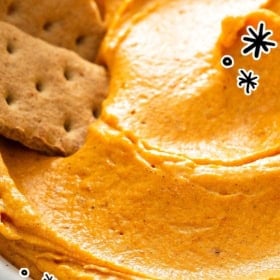 Close-up of creamy pumpkin dip in a bowl, garnished with graham crackers.