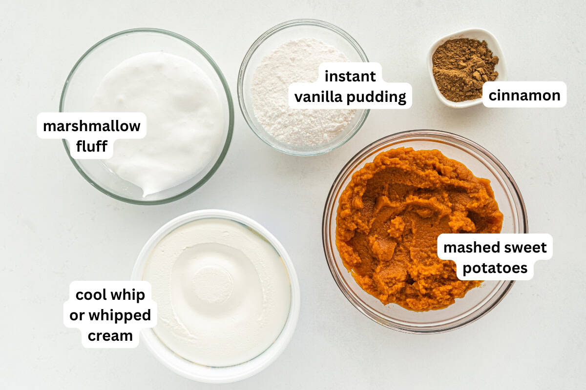 This Sweet Potato Pie Dip tastes like a classic sweet potato pie, but in a scoopable form. Serve it with gingersnaps or graham crackers! Five labeled bowls with marshmallow fluff, instant vanilla pudding, cinnamon, mashed sweet potatoes, and cool whip or whipped cream on a white surface.